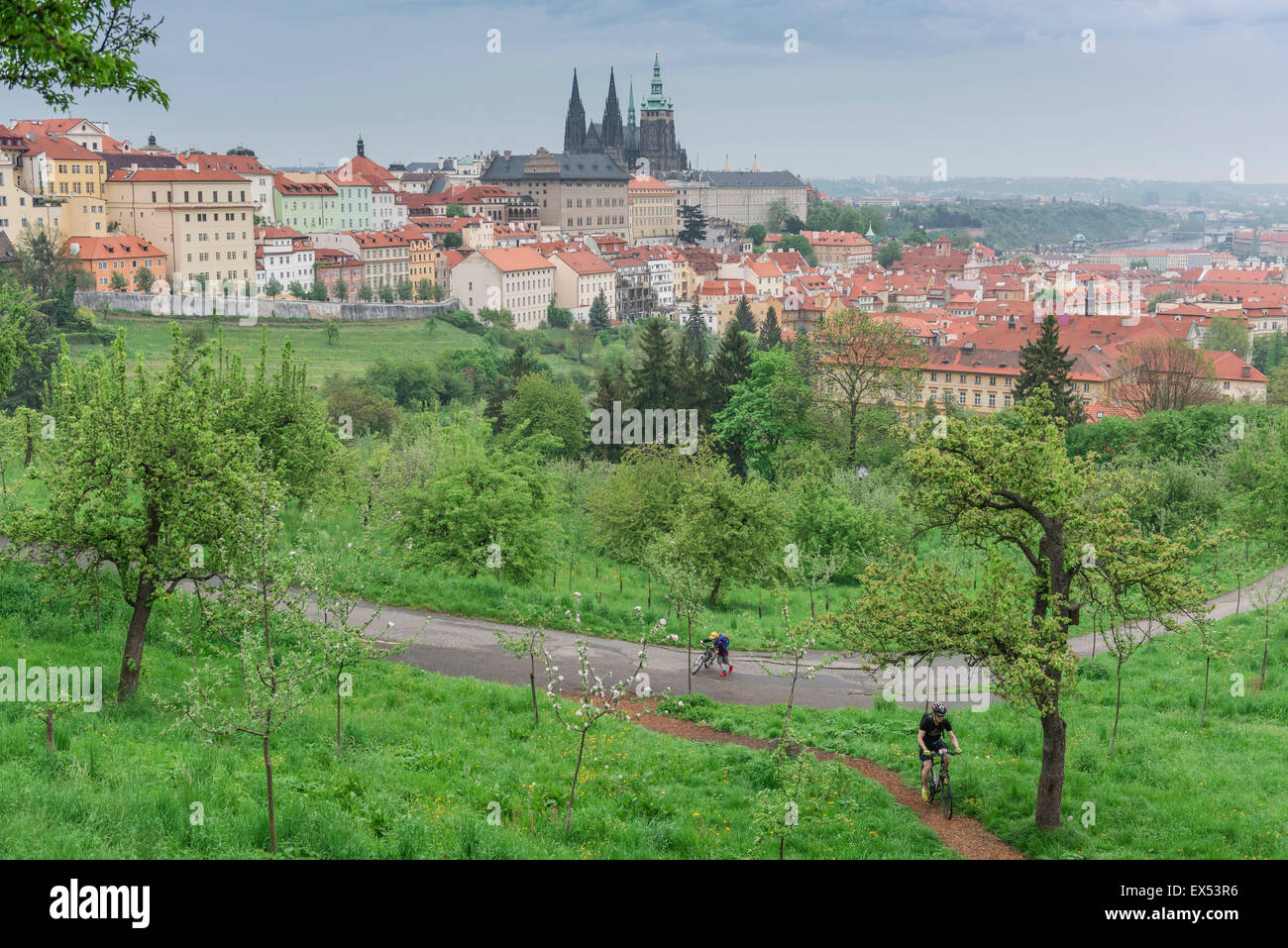 Petrin Hill, Blick auf einen Vater und seinen Sohn, der durch den Petrin Hill Park mit der Kathedrale auf der Skyline, Prag, Tschechien, radelt Stockfoto
