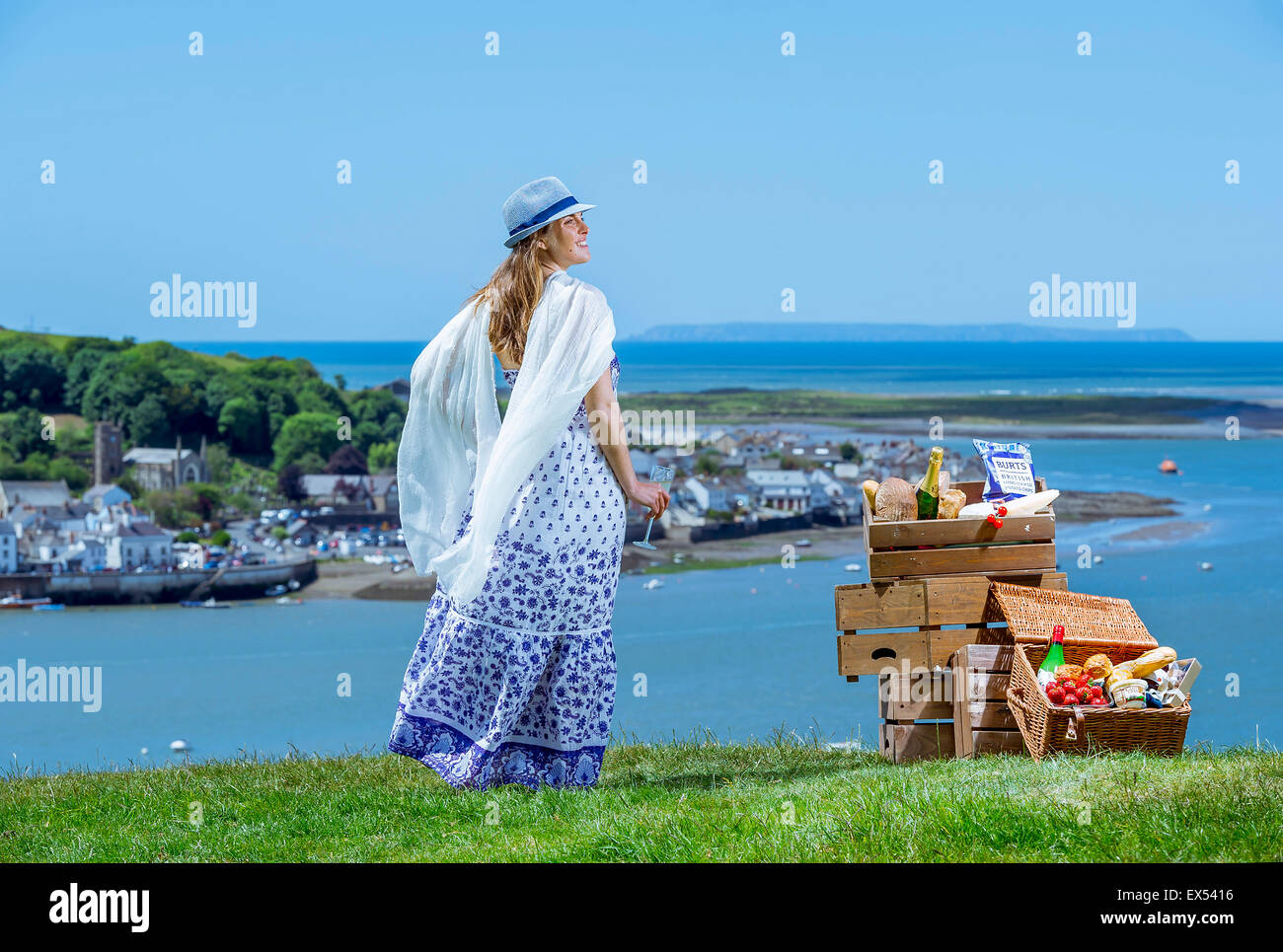 Eine schöne junge Frau mit Champagner und einem Picknickkorb sieht in Appledore an der Nordküste von Devon Stockfoto