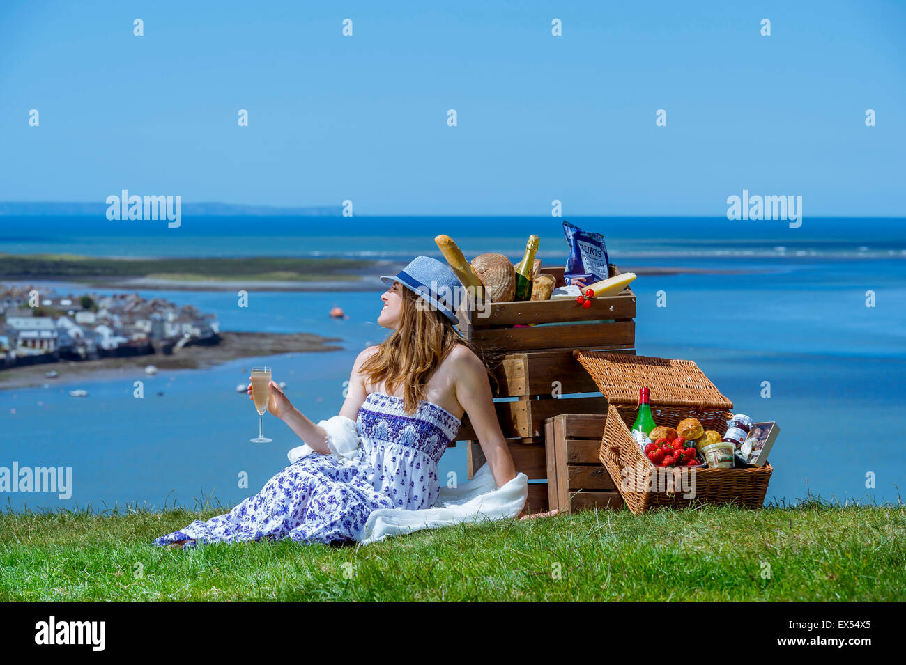 Eine schöne junge Frau mit Champagner und einem Picknickkorb sieht in Appledore an der Nordküste von Devon Stockfoto
