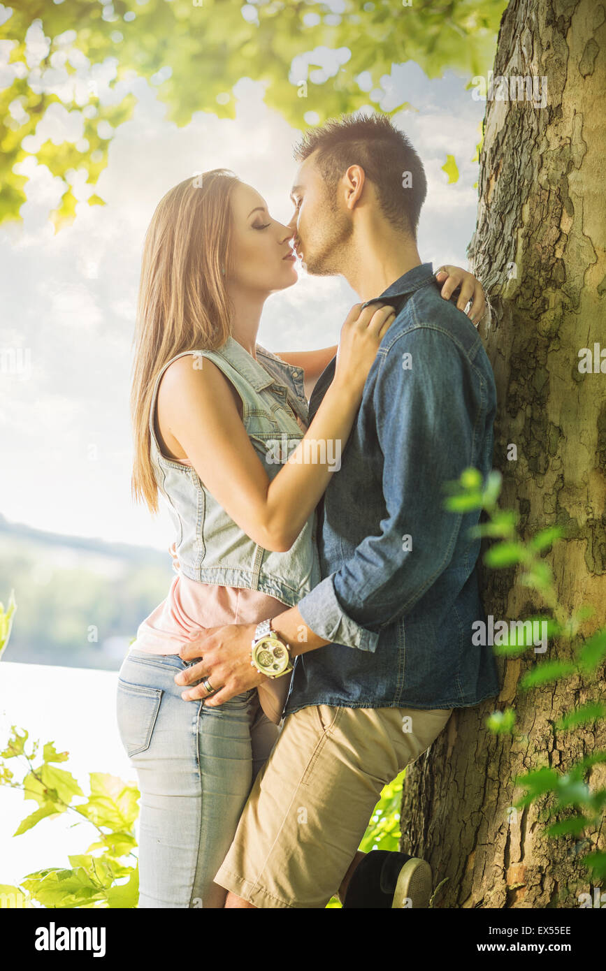 Liebespaar am See, unter den Bäumen, küssen Stockfoto