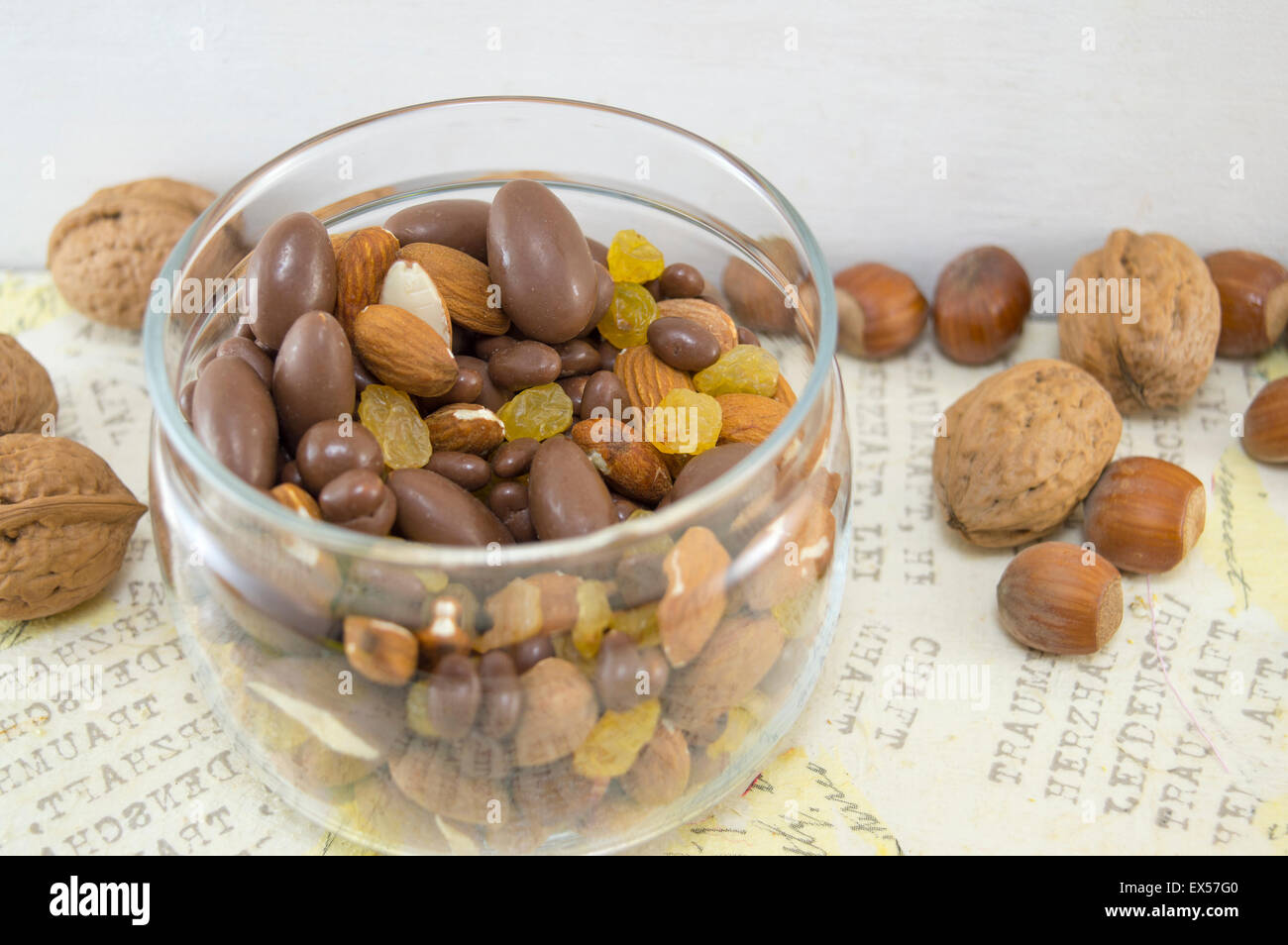 Snack-Mix aus Nüssen, Rosinen, Haselnüsse, Mandeln und Schokolade in der Schüssel auf dem Tisch Serviettentechnik dekoriert Stockfoto