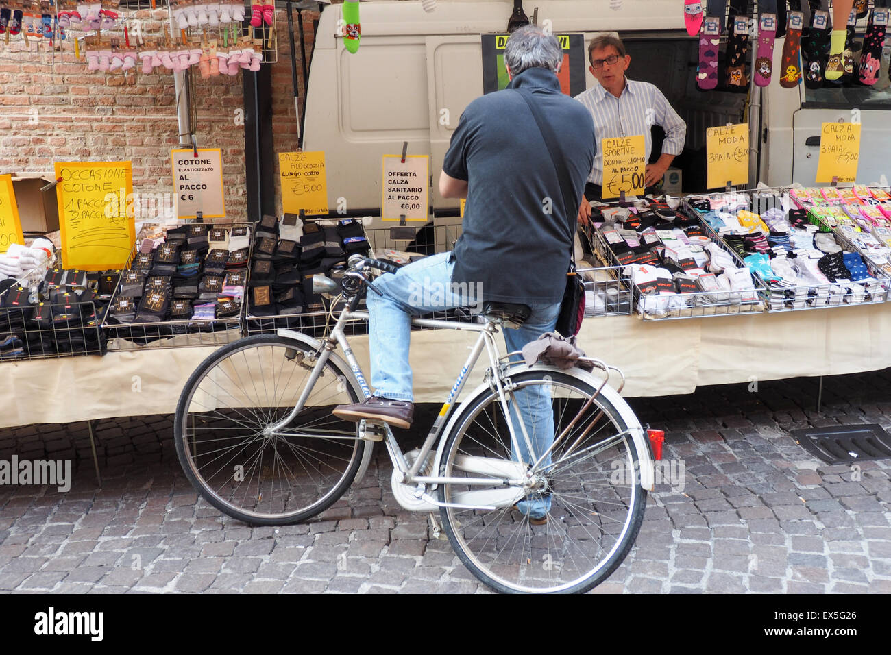 Ein männlicher Shopper auf seinem Fahrrad an einer im Markt. Stockfoto