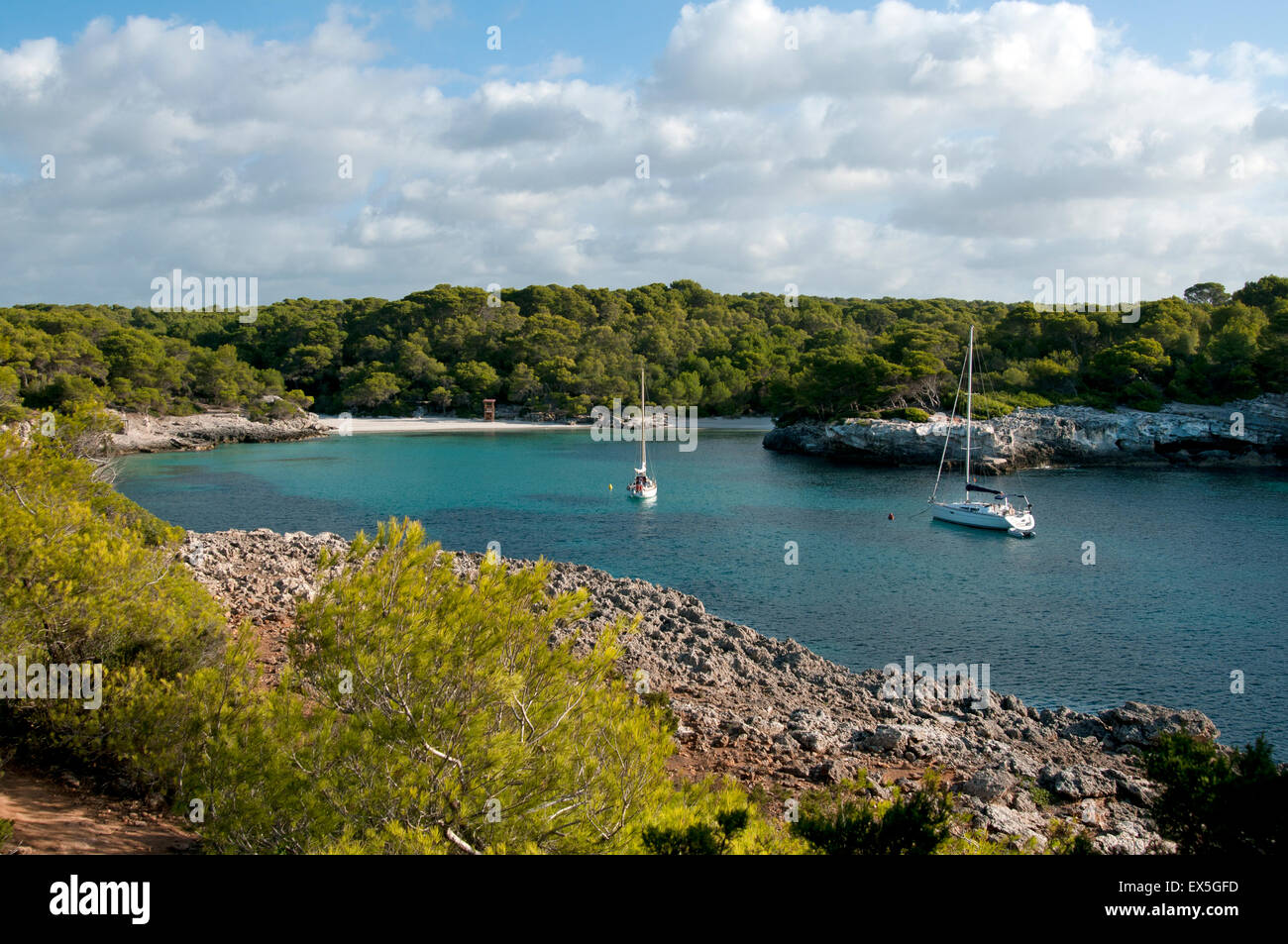 Zwei Segelyachten vor Anker in den ruhigen türkisfarbenen Gewässern bei Cala Turqueta auf der Insel Menorca Spanien Stockfoto