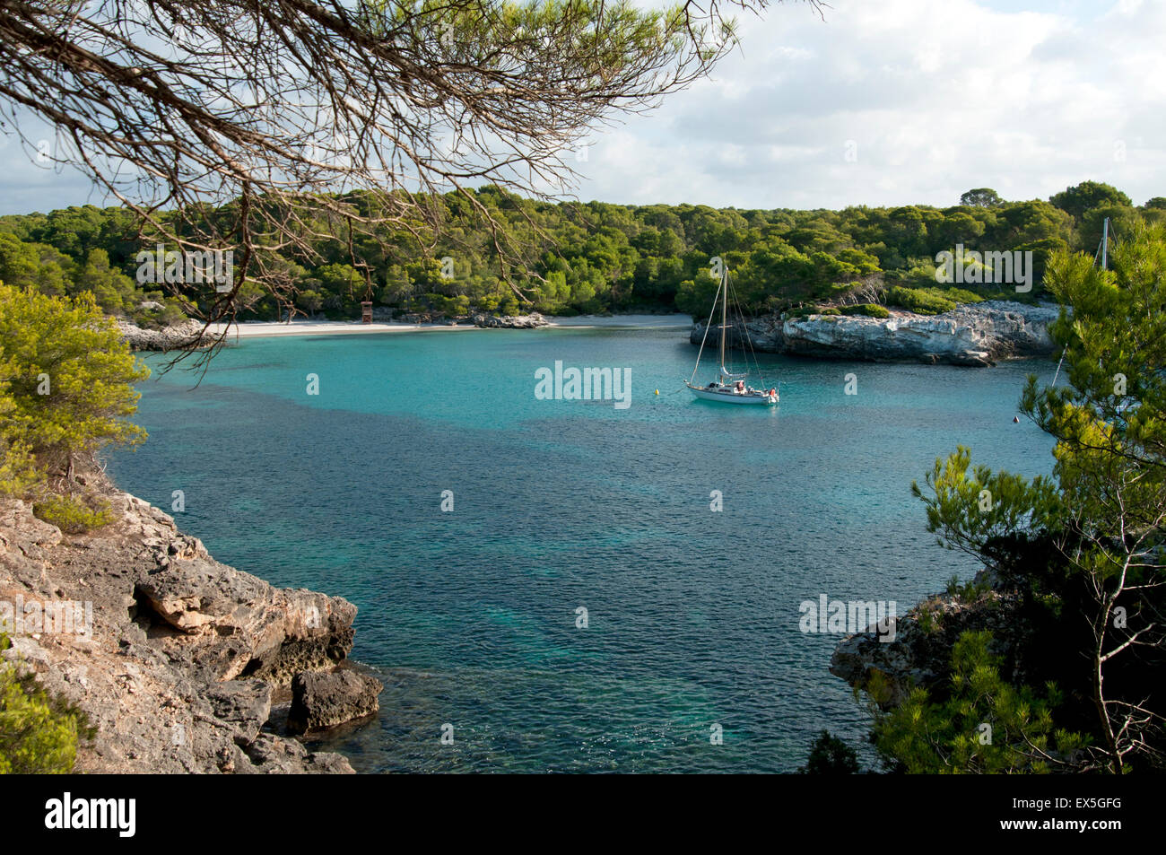 Eine Segelyacht vor Anker in den ruhigen türkisfarbenen Gewässern bei Cala Turqueta auf der Insel Menorca Spanien Stockfoto