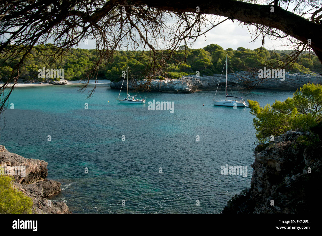 Zwei Segelyachten vor Anker in den ruhigen türkisfarbenen Gewässern bei Cala Turqueta auf der Insel Menorca Spanien Stockfoto
