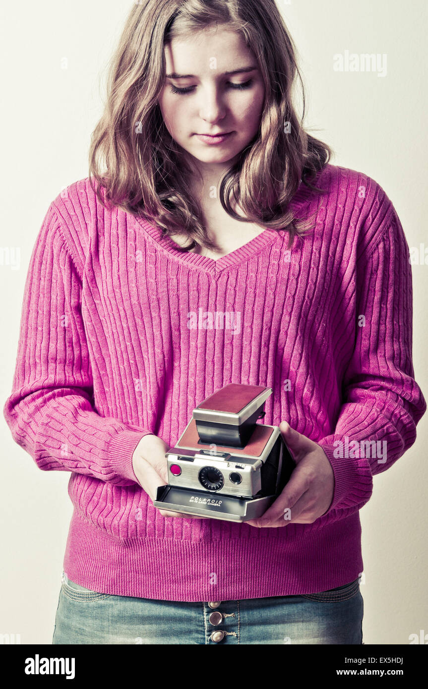 schen Mädchen hält eine Kamera Polaroid SX70 Stockfoto