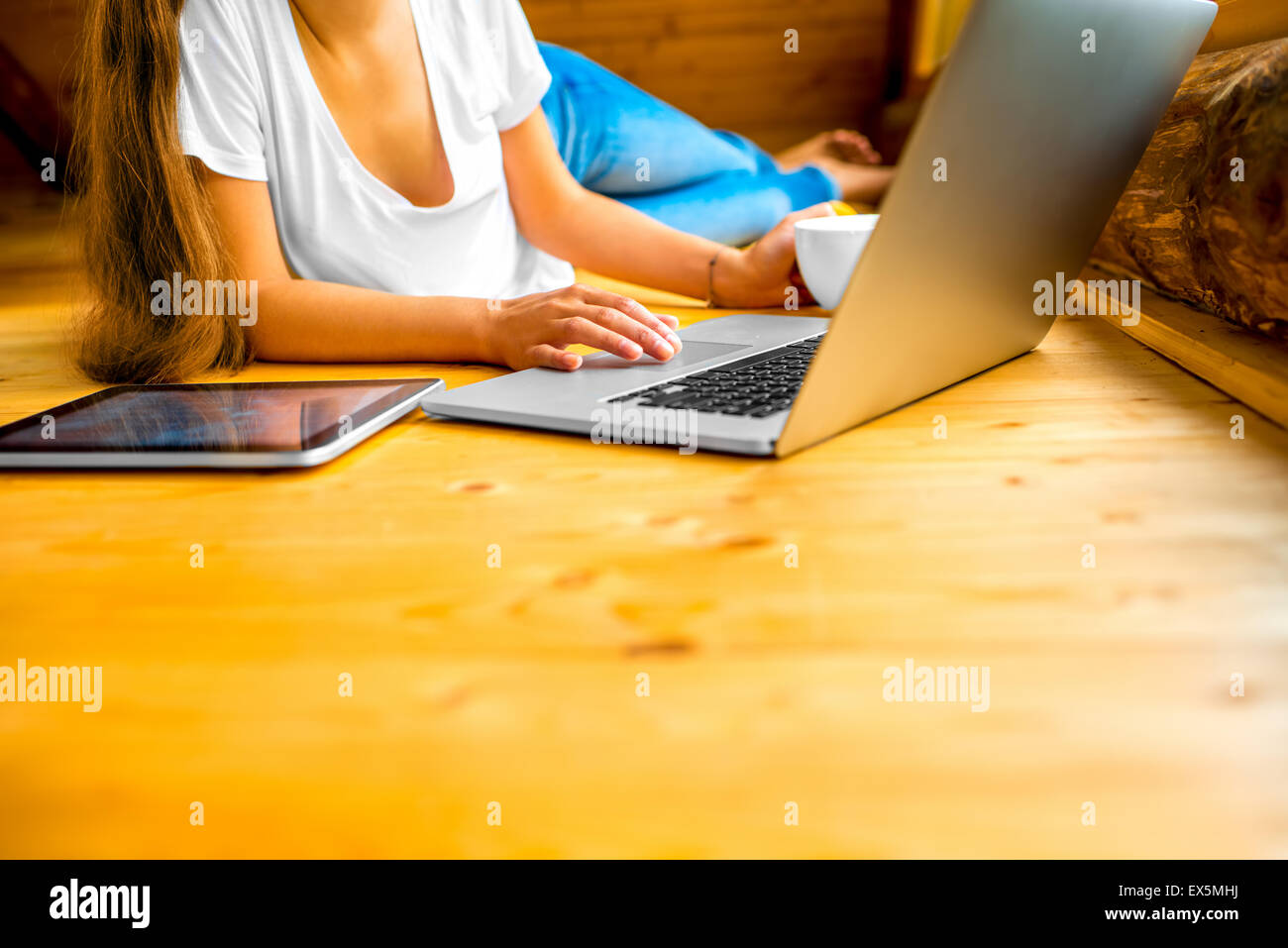 Frau mit Laptop auf dem Holzboden Stockfoto