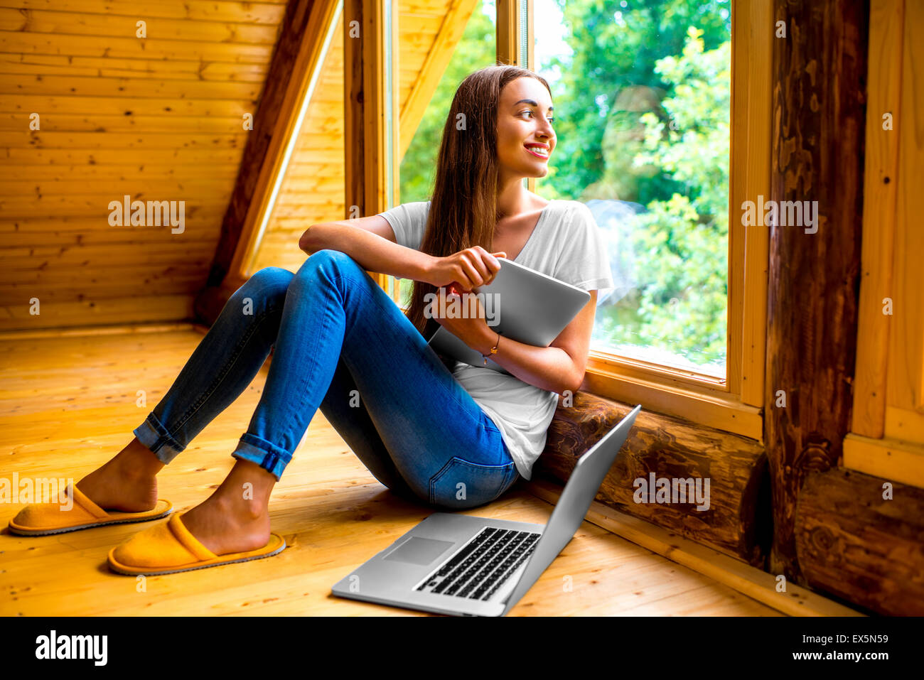 Frau mit Tablet-PC in der Nähe der Fenster im Haus Stockfoto