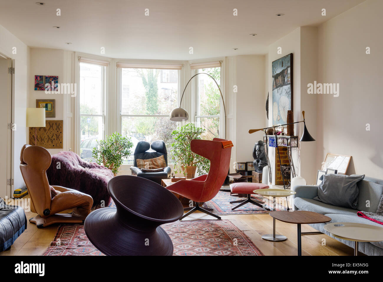 Runder Stuhl von Thomas Heatherwick im Wohnzimmer mit blassen Conran Sofa, marokkanische Teppiche und Bogenlampe von Archille Castiglione Stockfoto