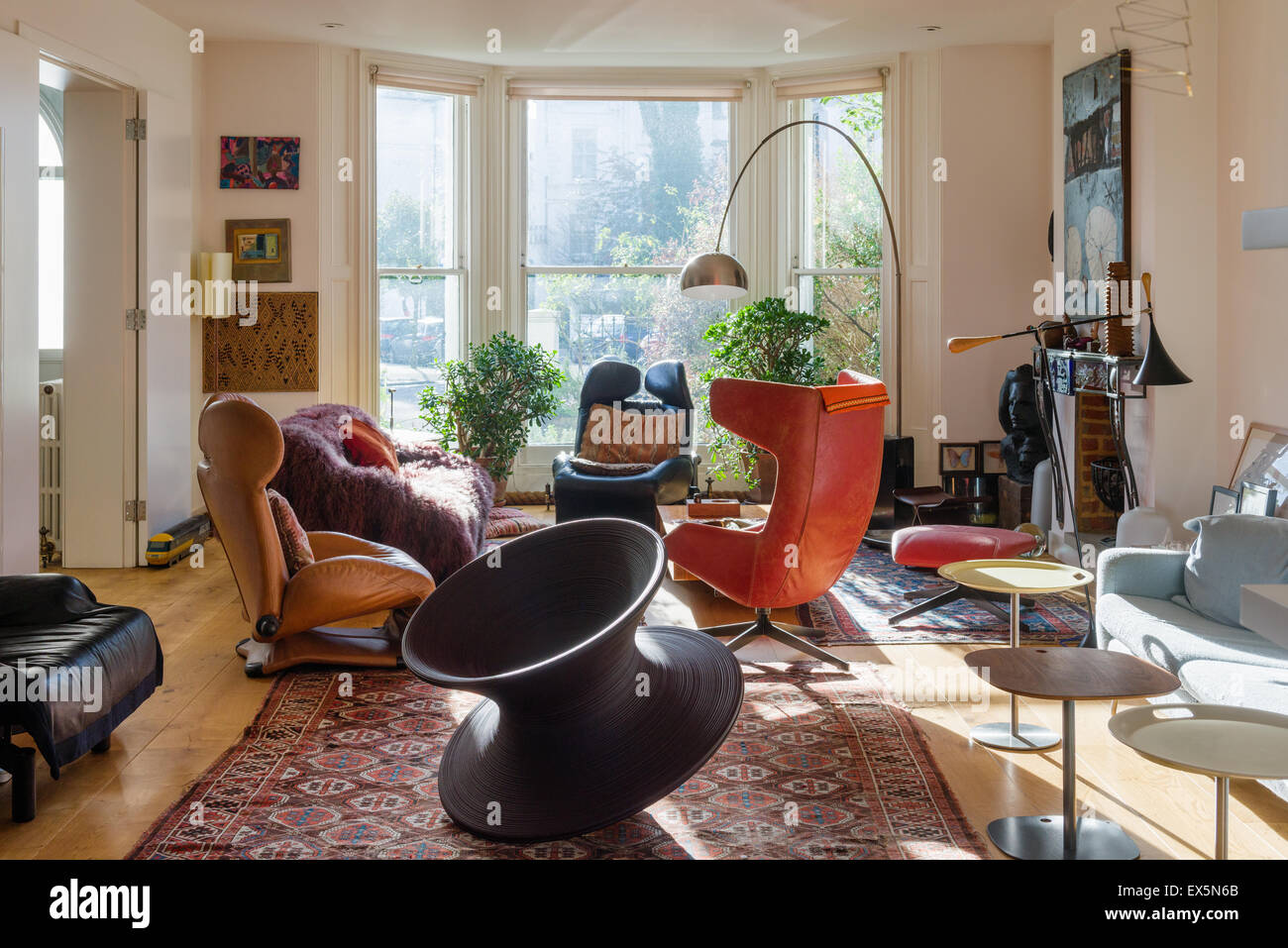 Runder Stuhl von Thomas Heatherwick im Wohnzimmer mit blassen Conran Sofa, marokkanische Teppiche und Bogenlampe von Archille Castiglione Stockfoto