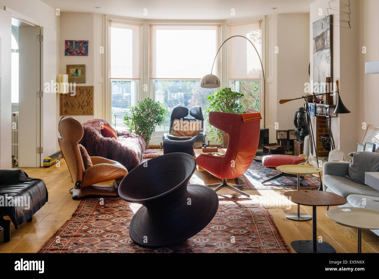 Runder Stuhl von Thomas Heatherwick im Wohnzimmer mit blass Conran Sofa, marokkanische Teppiche und Bogenlampe von Archille Castiglione Stockfoto