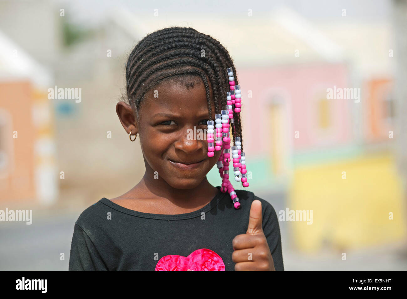 Kreolische Mädchen mit geflochtenen Haaren verziert mit bunten Perlen auftauchend Daumen auf der Insel Boa Vista, Kap Verde, Afrika Stockfoto