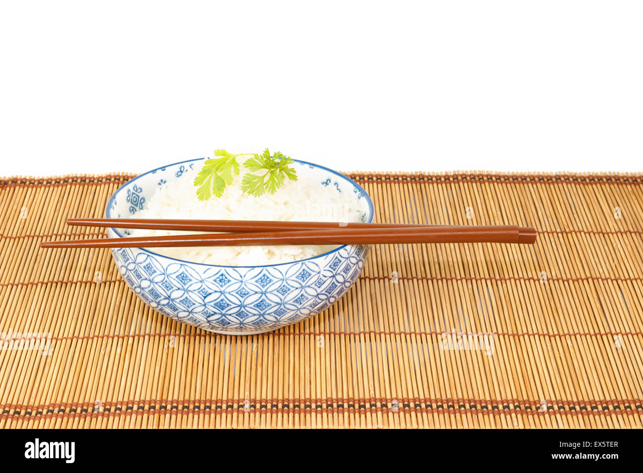 Schüssel Reis mit Stäbchen verziert mit gebratenen Zwiebeln und Koriander auf weißen Hintergrund Stockfoto