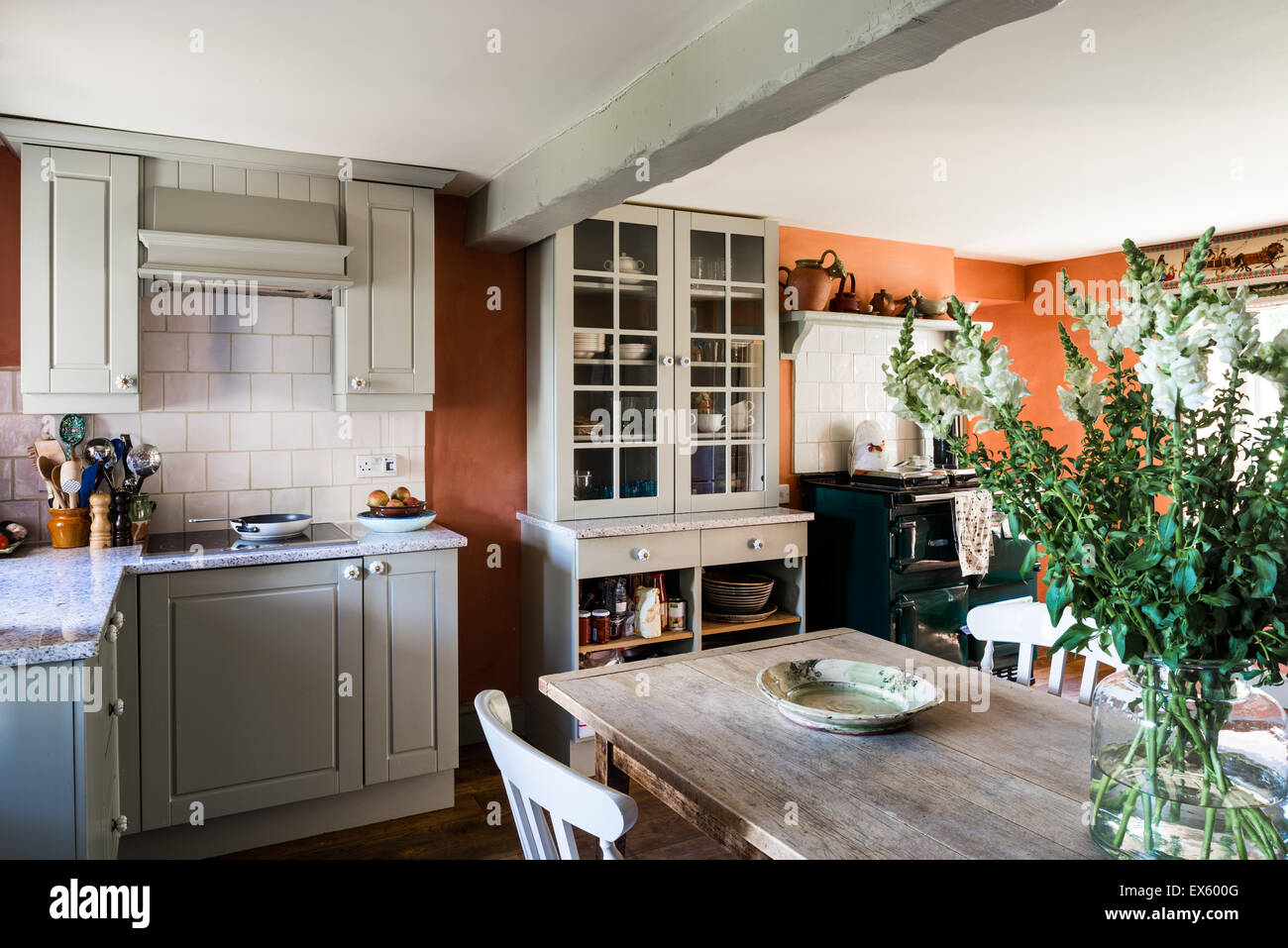 Landhausküche mit Holzbalken Decke, französische Bauernhof Stühle Tisch und Fenster. Die Einheiten sind in Französisch grau von Farrow & Ball gemalt. Stockfoto