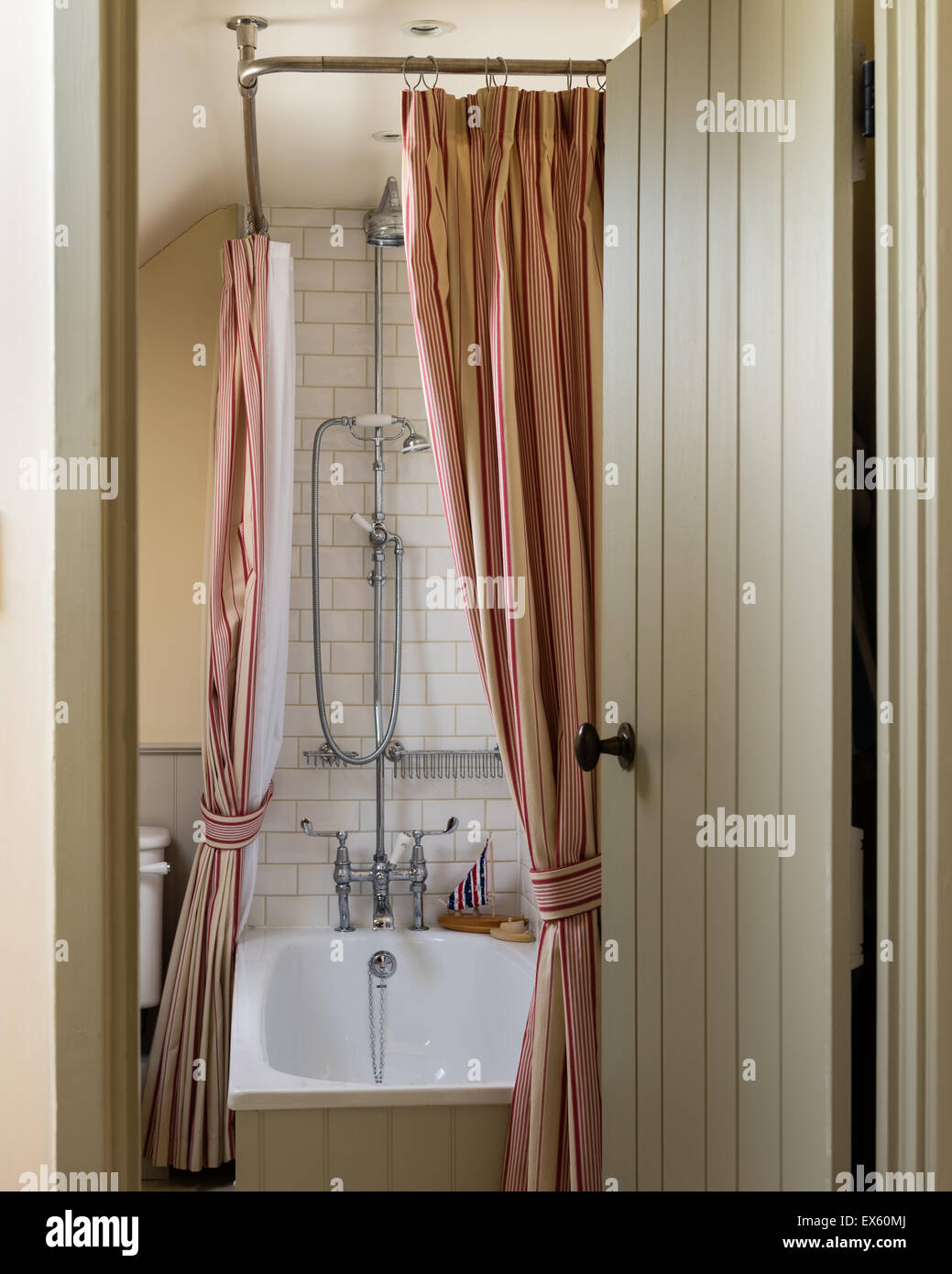 Blick durch die offene Tür zum Badezimmer. Der Duschvorhang ist aus Ian Mankin Stoff gefertigt. Stockfoto
