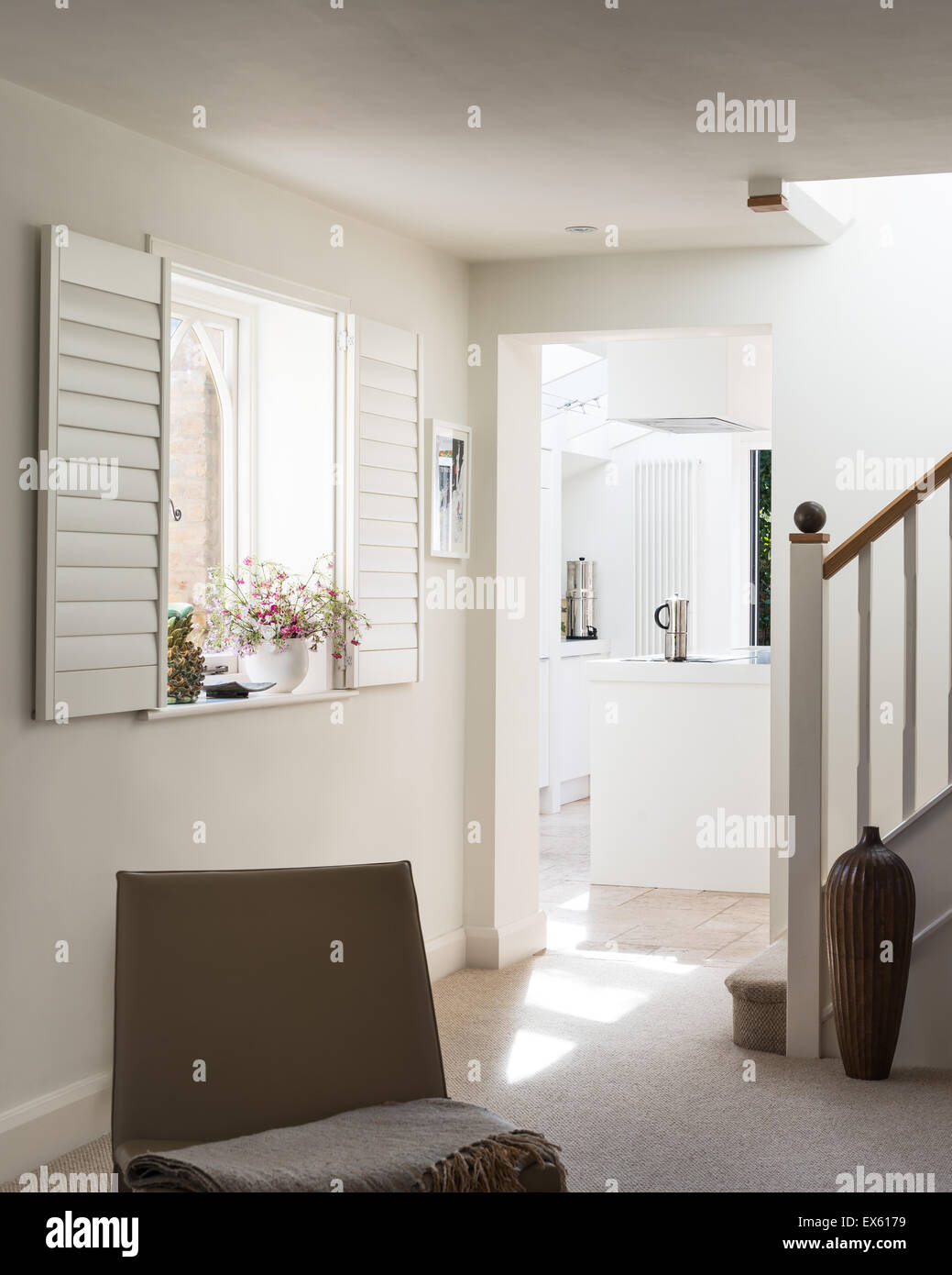 Haferflocken-Teppich im Wohnzimmer mit weißen Fensterläden und Mangowood vase Stockfoto