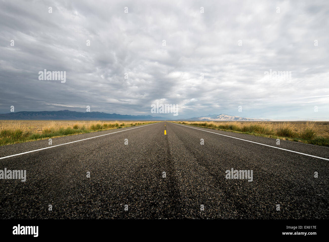 Leerer Landstraße mit bewölktem Himmel fotografiert aus einem niedrigen Winkel mit einem Weitwinkel-Objektiv Stockfoto