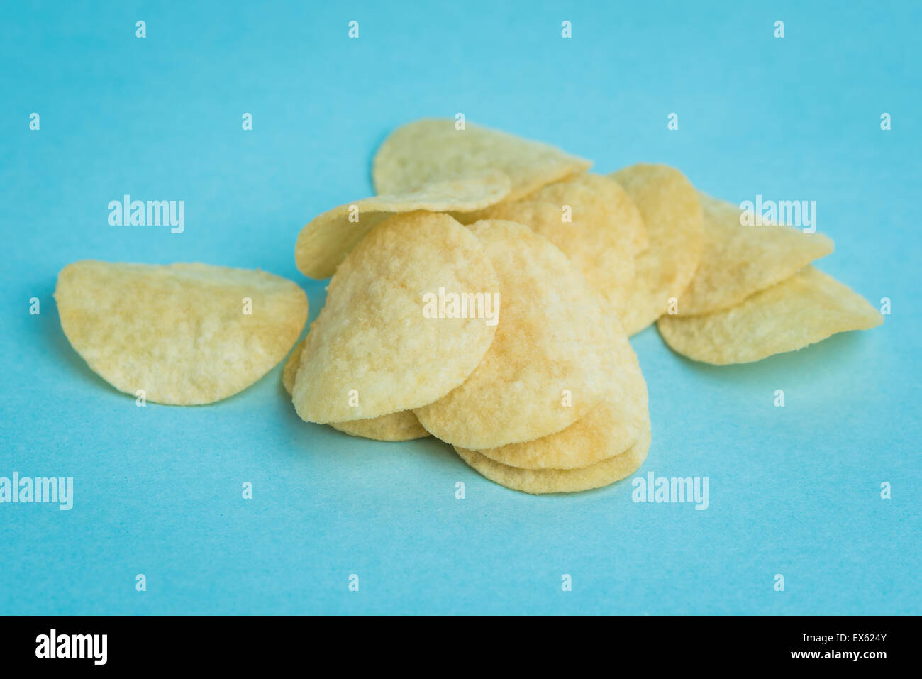 Eine Makroaufnahme Mini Kartoffel-Chips auf einem blauen Hintergrund. Stockfoto