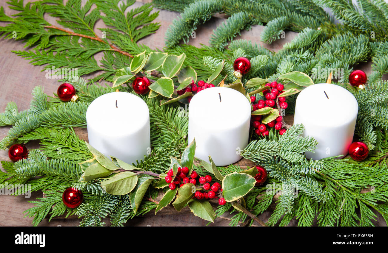 Drei weiße Kerzen in ein Weihnachts-Mittelstück Stockfoto