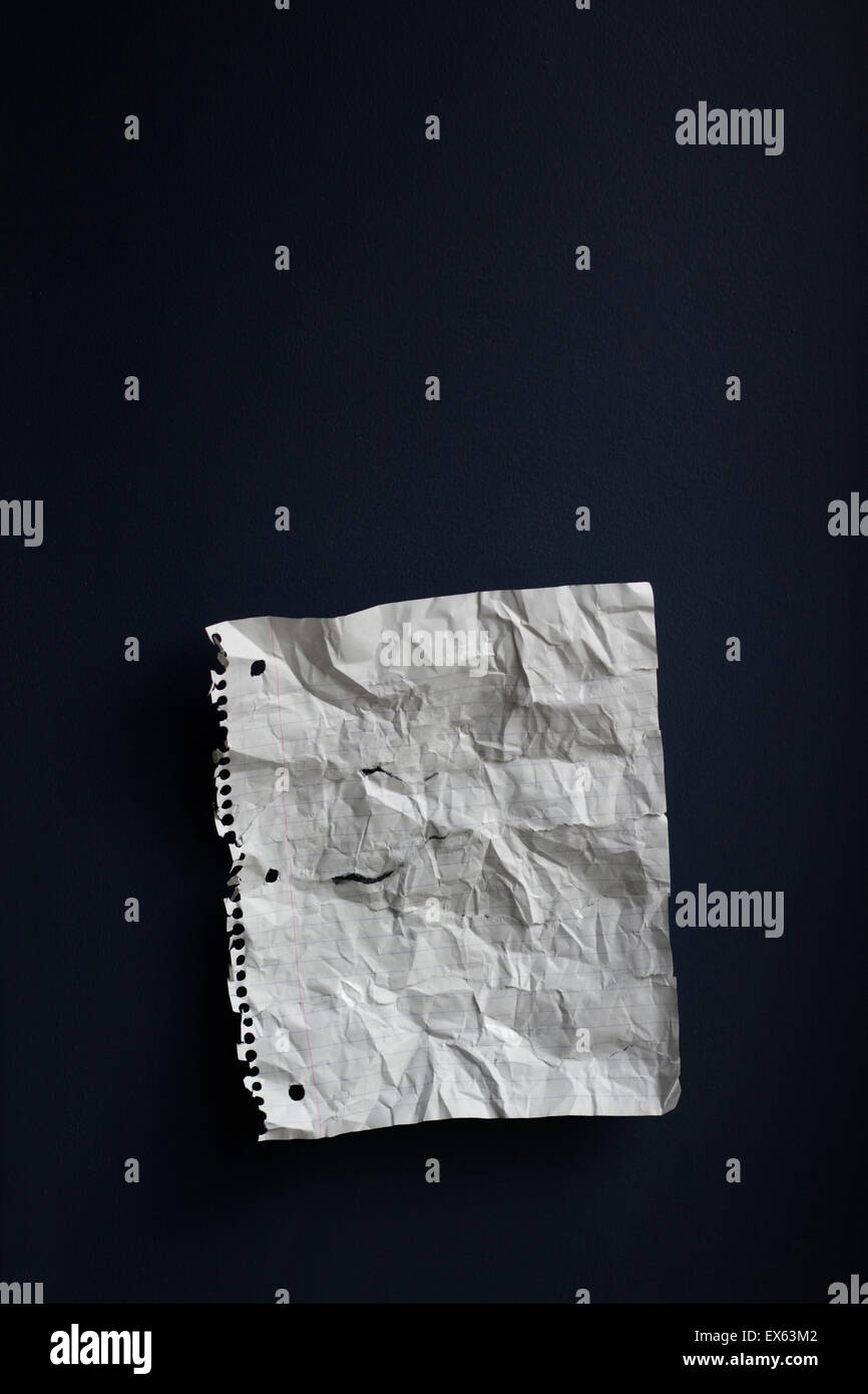 Ein zerknülltes Stück Papier Notebook vor einem dunklen Hintergrund. Stockfoto
