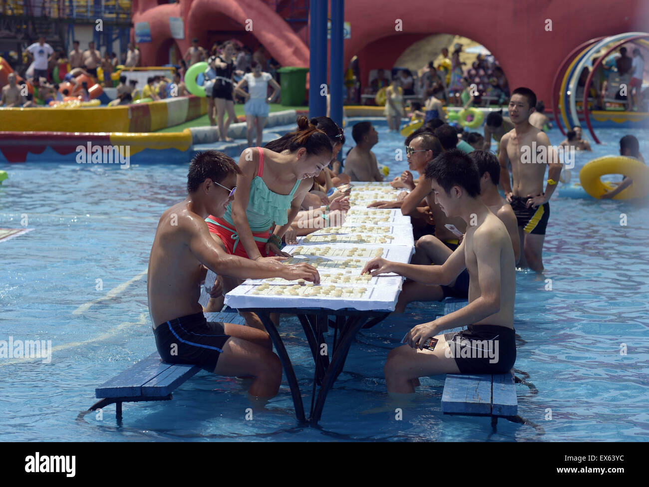 Chongqing, Chongqing, CHN. 7. Juli 2015. Chongqing, CHINA - 7. Juli 2015: (Nur zur redaktionellen Verwendung. CHINA aus) Menschen erleben Sie die Freude des Spielens chinesisches Schach im Wasser während einer Schachpartie im Wasserpark auf Yangren Straße. Wie Chongqing in heißen Tagen kommt, kurzem Wasserpark in Yangren Straße Unterhaltung des chinesischen Schach im Wasser für Touristen Urlaub verbringen. Das Jaint Schachbrett ist 20ãŽ¡und der Durchmesser jedes Schachfigur beträgt 50 cm. Credit: SIPA Asien/ZUMA Draht/Alamy Live News Stockfoto
