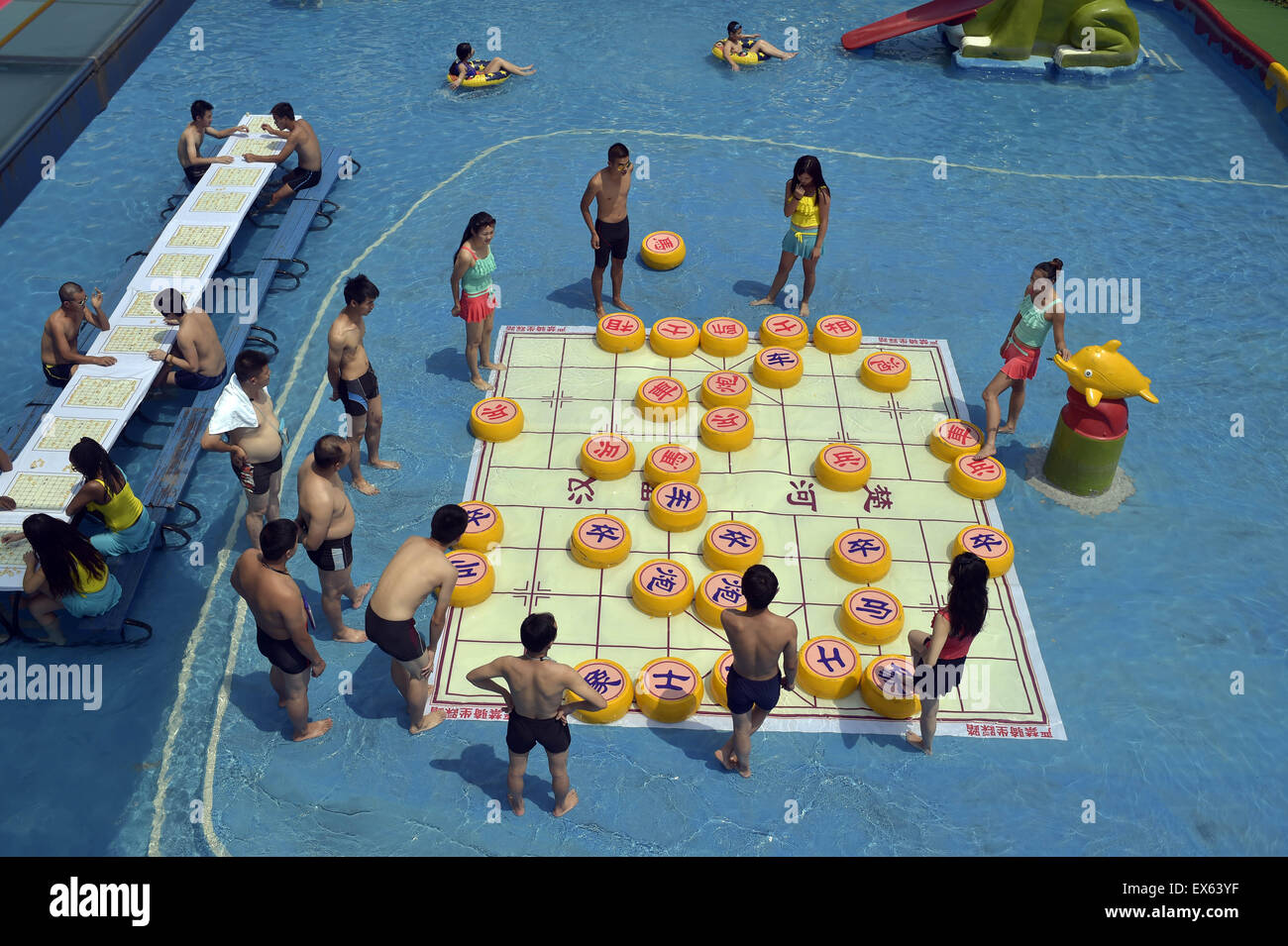 Chongqing, Chongqing, CHN. 7. Juli 2015. Chongqing, CHINA - 7. Juli 2015: (Nur zur redaktionellen Verwendung. CHINA aus) Menschen erleben Sie die Freude des Spielens chinesisches Schach im Wasser während einer Schachpartie im Wasserpark auf Yangren Straße. Wie Chongqing in heißen Tagen kommt, kurzem Wasserpark in Yangren Straße Unterhaltung des chinesischen Schach im Wasser für Touristen Urlaub verbringen. Das Jaint Schachbrett ist 20ãŽ¡und der Durchmesser jedes Schachfigur beträgt 50 cm. Credit: SIPA Asien/ZUMA Draht/Alamy Live News Stockfoto