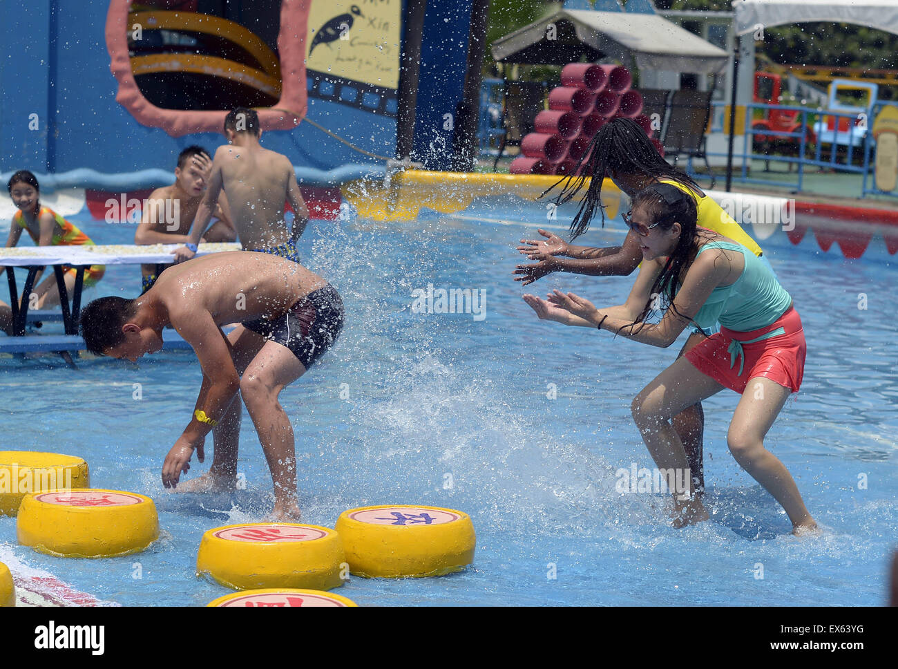Chongqing, Chongqing, CHN. 7. Juli 2015. Chongqing, CHINA - 7. Juli 2015: (Nur zur redaktionellen Verwendung. CHINA aus) Menschen erleben Sie die Freude des Spielens chinesisches Schach im Wasser während einer Schachpartie im Wasserpark auf Yangren Straße. Wie Chongqing in heißen Tagen kommt, kurzem Wasserpark in Yangren Straße Unterhaltung des chinesischen Schach im Wasser für Touristen Urlaub verbringen. Das Jaint Schachbrett ist 20ãŽ¡und der Durchmesser jedes Schachfigur beträgt 50 cm. Credit: SIPA Asien/ZUMA Draht/Alamy Live News Stockfoto