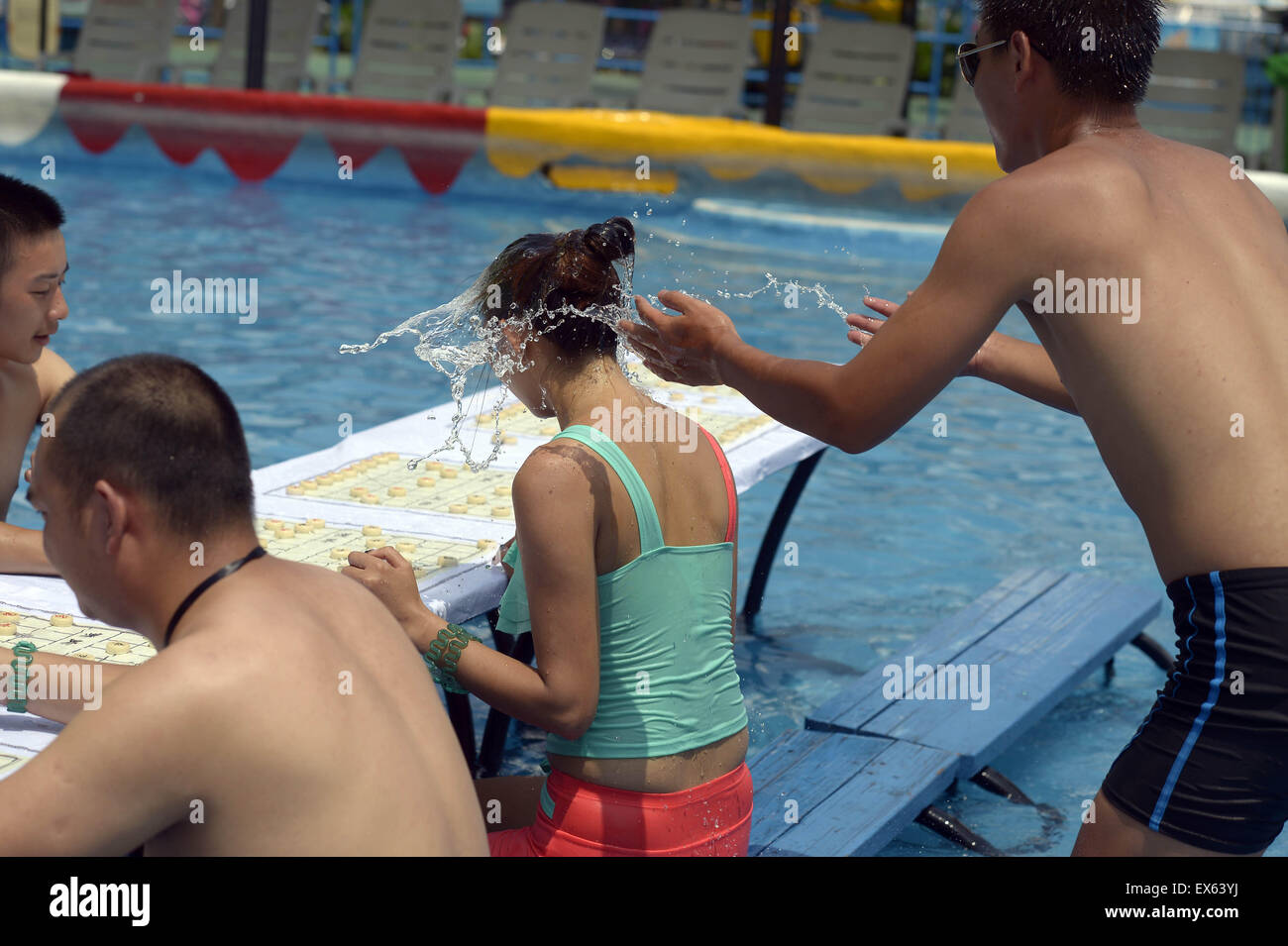 Chongqing, Chongqing, CHN. 7. Juli 2015. Chongqing, CHINA - 7. Juli 2015: (Nur zur redaktionellen Verwendung. CHINA aus) Menschen erleben Sie die Freude des Spielens chinesisches Schach im Wasser während einer Schachpartie im Wasserpark auf Yangren Straße. Wie Chongqing in heißen Tagen kommt, kurzem Wasserpark in Yangren Straße Unterhaltung des chinesischen Schach im Wasser für Touristen Urlaub verbringen. Das Jaint Schachbrett ist 20ãŽ¡und der Durchmesser jedes Schachfigur beträgt 50 cm. Credit: SIPA Asien/ZUMA Draht/Alamy Live News Stockfoto
