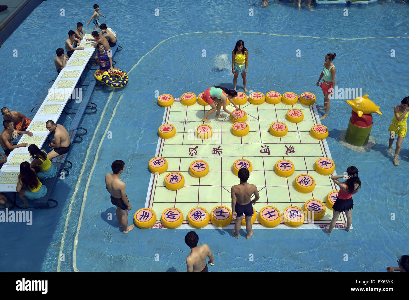 Chongqing, Chongqing, CHN. 7. Juli 2015. Chongqing, CHINA - 7. Juli 2015: (Nur zur redaktionellen Verwendung. CHINA aus) Menschen erleben Sie die Freude des Spielens chinesisches Schach im Wasser während einer Schachpartie im Wasserpark auf Yangren Straße. Wie Chongqing in heißen Tagen kommt, kurzem Wasserpark in Yangren Straße Unterhaltung des chinesischen Schach im Wasser für Touristen Urlaub verbringen. Das Jaint Schachbrett ist 20ãŽ¡und der Durchmesser jedes Schachfigur beträgt 50 cm. Credit: SIPA Asien/ZUMA Draht/Alamy Live News Stockfoto