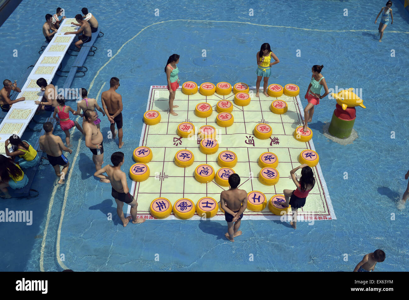 Chongqing, Chongqing, CHN. 7. Juli 2015. Chongqing, CHINA - 7. Juli 2015: (Nur zur redaktionellen Verwendung. CHINA aus) Menschen erleben Sie die Freude des Spielens chinesisches Schach im Wasser während einer Schachpartie im Wasserpark auf Yangren Straße. Wie Chongqing in heißen Tagen kommt, kurzem Wasserpark in Yangren Straße Unterhaltung des chinesischen Schach im Wasser für Touristen Urlaub verbringen. Das Jaint Schachbrett ist 20ãŽ¡und der Durchmesser jedes Schachfigur beträgt 50 cm. Credit: SIPA Asien/ZUMA Draht/Alamy Live News Stockfoto