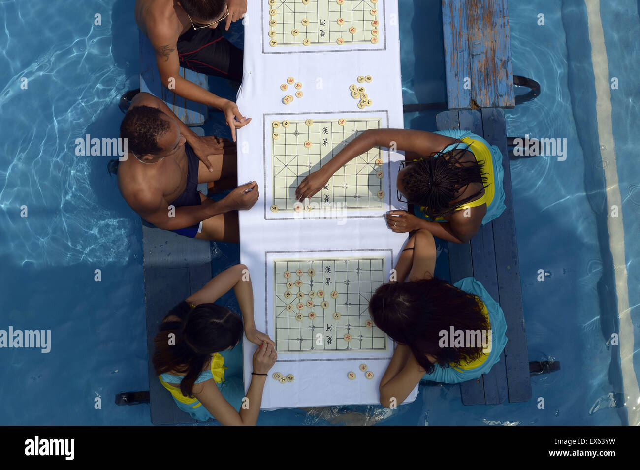 Chongqing, Chongqing, CHN. 7. Juli 2015. Chongqing, CHINA - 7. Juli 2015: (Nur zur redaktionellen Verwendung. CHINA aus) Menschen erleben Sie die Freude des Spielens chinesisches Schach im Wasser während einer Schachpartie im Wasserpark auf Yangren Straße. Wie Chongqing in heißen Tagen kommt, kurzem Wasserpark in Yangren Straße Unterhaltung des chinesischen Schach im Wasser für Touristen Urlaub verbringen. Das Jaint Schachbrett ist 20ãŽ¡und der Durchmesser jedes Schachfigur beträgt 50 cm. Credit: SIPA Asien/ZUMA Draht/Alamy Live News Stockfoto