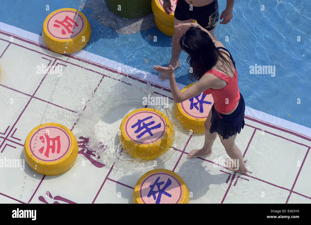 Chongqing, Chongqing, CHN. 7. Juli 2015. Chongqing, CHINA - 7. Juli 2015: (Nur zur redaktionellen Verwendung. CHINA aus) Menschen erleben Sie die Freude des Spielens chinesisches Schach im Wasser während einer Schachpartie im Wasserpark auf Yangren Straße. Wie Chongqing in heißen Tagen kommt, kurzem Wasserpark in Yangren Straße Unterhaltung des chinesischen Schach im Wasser für Touristen Urlaub verbringen. Das Jaint Schachbrett ist 20ãŽ¡und der Durchmesser jedes Schachfigur beträgt 50 cm. Credit: SIPA Asien/ZUMA Draht/Alamy Live News Stockfoto