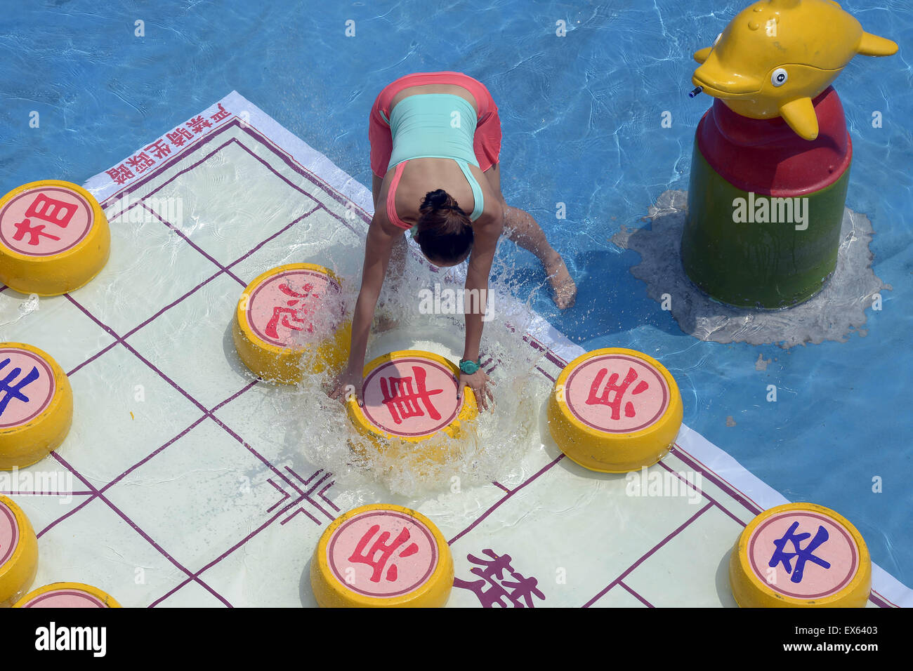 Chongqing, Chongqing, CHN. 7. Juli 2015. Chongqing, CHINA - 7. Juli 2015: (Nur zur redaktionellen Verwendung. CHINA aus) Menschen erleben Sie die Freude des Spielens chinesisches Schach im Wasser während einer Schachpartie im Wasserpark auf Yangren Straße. Wie Chongqing in heißen Tagen kommt, kurzem Wasserpark in Yangren Straße Unterhaltung des chinesischen Schach im Wasser für Touristen Urlaub verbringen. Das Jaint Schachbrett ist 20ãŽ¡und der Durchmesser jedes Schachfigur beträgt 50 cm. Credit: SIPA Asien/ZUMA Draht/Alamy Live News Stockfoto