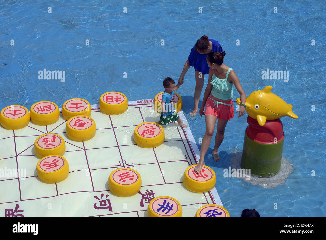 Chongqing, Chongqing, CHN. 7. Juli 2015. Chongqing, CHINA - 7. Juli 2015: (Nur zur redaktionellen Verwendung. CHINA aus) Menschen erleben Sie die Freude des Spielens chinesisches Schach im Wasser während einer Schachpartie im Wasserpark auf Yangren Straße. Wie Chongqing in heißen Tagen kommt, kurzem Wasserpark in Yangren Straße Unterhaltung des chinesischen Schach im Wasser für Touristen Urlaub verbringen. Das Jaint Schachbrett ist 20ãŽ¡und der Durchmesser jedes Schachfigur beträgt 50 cm. Credit: SIPA Asien/ZUMA Draht/Alamy Live News Stockfoto