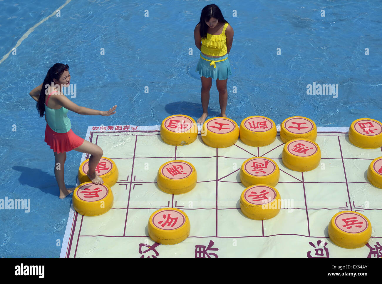 Chongqing, Chongqing, CHN. 7. Juli 2015. Chongqing, CHINA - 7. Juli 2015: (Nur zur redaktionellen Verwendung. CHINA aus) Menschen erleben Sie die Freude des Spielens chinesisches Schach im Wasser während einer Schachpartie im Wasserpark auf Yangren Straße. Wie Chongqing in heißen Tagen kommt, kurzem Wasserpark in Yangren Straße Unterhaltung des chinesischen Schach im Wasser für Touristen Urlaub verbringen. Das Jaint Schachbrett ist 20ãŽ¡und der Durchmesser jedes Schachfigur beträgt 50 cm. Credit: SIPA Asien/ZUMA Draht/Alamy Live News Stockfoto