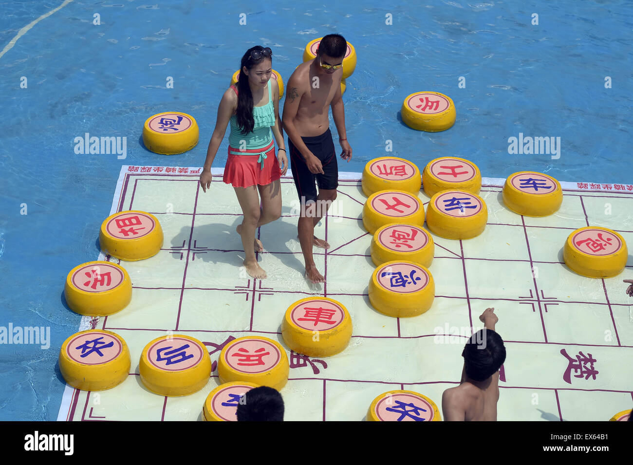 Chongqing, Chongqing, CHN. 7. Juli 2015. Chongqing, CHINA - 7. Juli 2015: (Nur zur redaktionellen Verwendung. CHINA aus) Menschen erleben Sie die Freude des Spielens chinesisches Schach im Wasser während einer Schachpartie im Wasserpark auf Yangren Straße. Wie Chongqing in heißen Tagen kommt, kurzem Wasserpark in Yangren Straße Unterhaltung des chinesischen Schach im Wasser für Touristen Urlaub verbringen. Das Jaint Schachbrett ist 20ãŽ¡und der Durchmesser jedes Schachfigur beträgt 50 cm. Credit: SIPA Asien/ZUMA Draht/Alamy Live News Stockfoto