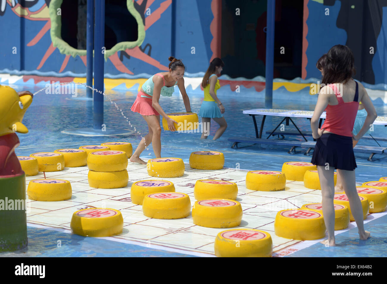 Chongqing, Chongqing, CHN. 7. Juli 2015. Chongqing, CHINA - 7. Juli 2015: (Nur zur redaktionellen Verwendung. CHINA aus) Menschen erleben Sie die Freude des Spielens chinesisches Schach im Wasser während einer Schachpartie im Wasserpark auf Yangren Straße. Wie Chongqing in heißen Tagen kommt, kurzem Wasserpark in Yangren Straße Unterhaltung des chinesischen Schach im Wasser für Touristen Urlaub verbringen. Das Jaint Schachbrett ist 20ãŽ¡und der Durchmesser jedes Schachfigur beträgt 50 cm. Credit: SIPA Asien/ZUMA Draht/Alamy Live News Stockfoto