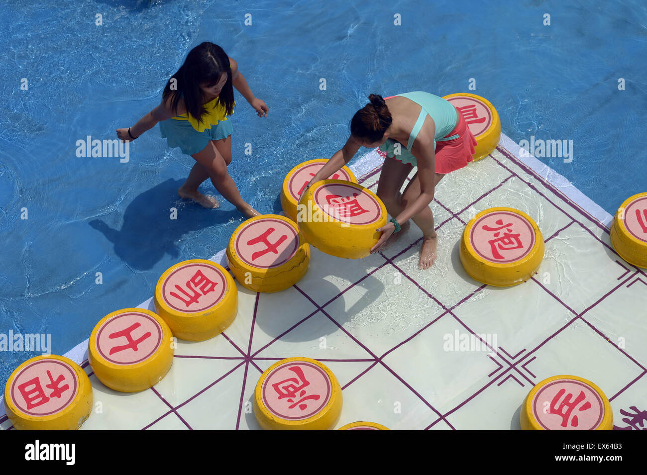 Chongqing, Chongqing, CHN. 7. Juli 2015. Chongqing, CHINA - 7. Juli 2015: (Nur zur redaktionellen Verwendung. CHINA aus) Menschen erleben Sie die Freude des Spielens chinesisches Schach im Wasser während einer Schachpartie im Wasserpark auf Yangren Straße. Wie Chongqing in heißen Tagen kommt, kurzem Wasserpark in Yangren Straße Unterhaltung des chinesischen Schach im Wasser für Touristen Urlaub verbringen. Das Jaint Schachbrett ist 20ãŽ¡und der Durchmesser jedes Schachfigur beträgt 50 cm. Credit: SIPA Asien/ZUMA Draht/Alamy Live News Stockfoto