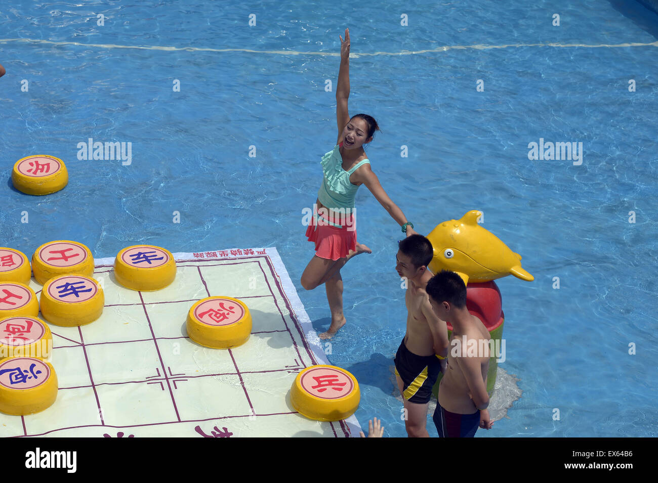 Chongqing, Chongqing, CHN. 7. Juli 2015. Chongqing, CHINA - 7. Juli 2015: (Nur zur redaktionellen Verwendung. CHINA aus) Menschen erleben Sie die Freude des Spielens chinesisches Schach im Wasser während einer Schachpartie im Wasserpark auf Yangren Straße. Wie Chongqing in heißen Tagen kommt, kurzem Wasserpark in Yangren Straße Unterhaltung des chinesischen Schach im Wasser für Touristen Urlaub verbringen. Das Jaint Schachbrett ist 20ãŽ¡und der Durchmesser jedes Schachfigur beträgt 50 cm. Credit: SIPA Asien/ZUMA Draht/Alamy Live News Stockfoto