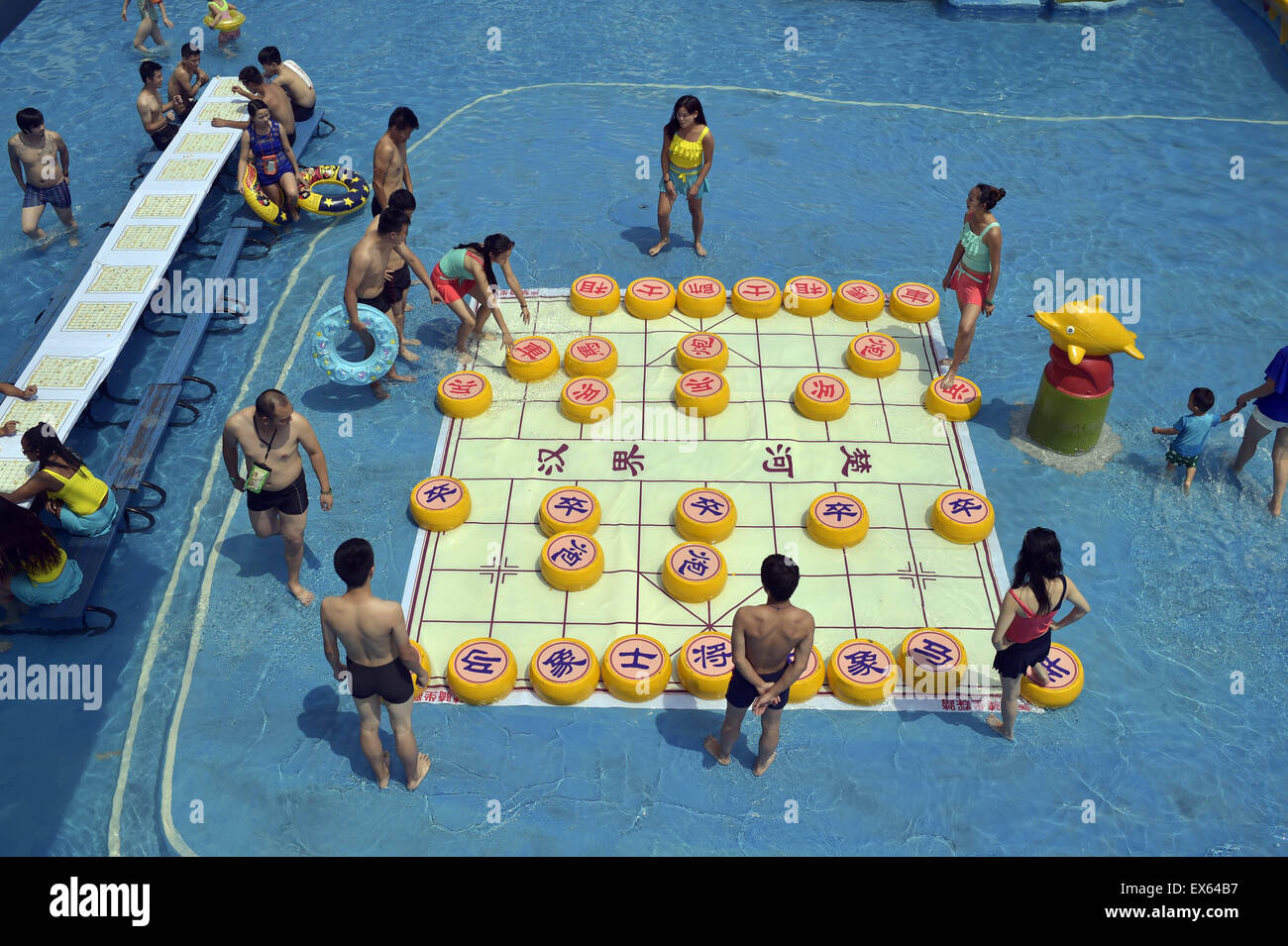Chongqing, Chongqing, CHN. 7. Juli 2015. Chongqing, CHINA - 7. Juli 2015: (Nur zur redaktionellen Verwendung. CHINA aus) Menschen erleben Sie die Freude des Spielens chinesisches Schach im Wasser während einer Schachpartie im Wasserpark auf Yangren Straße. Wie Chongqing in heißen Tagen kommt, kurzem Wasserpark in Yangren Straße Unterhaltung des chinesischen Schach im Wasser für Touristen Urlaub verbringen. Das Jaint Schachbrett ist 20ãŽ¡und der Durchmesser jedes Schachfigur beträgt 50 cm. Credit: SIPA Asien/ZUMA Draht/Alamy Live News Stockfoto