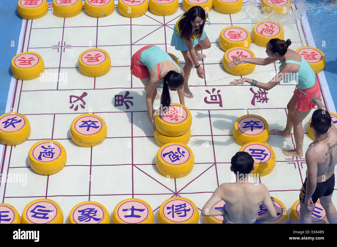Chongqing, Chongqing, CHN. 7. Juli 2015. Chongqing, CHINA - 7. Juli 2015: (Nur zur redaktionellen Verwendung. CHINA aus) Menschen erleben Sie die Freude des Spielens chinesisches Schach im Wasser während einer Schachpartie im Wasserpark auf Yangren Straße. Wie Chongqing in heißen Tagen kommt, kurzem Wasserpark in Yangren Straße Unterhaltung des chinesischen Schach im Wasser für Touristen Urlaub verbringen. Das Jaint Schachbrett ist 20ãŽ¡und der Durchmesser jedes Schachfigur beträgt 50 cm. Credit: SIPA Asien/ZUMA Draht/Alamy Live News Stockfoto