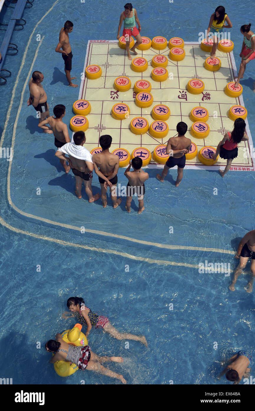 Chongqing, Chongqing, CHN. 7. Juli 2015. Chongqing, CHINA - 7. Juli 2015: (Nur zur redaktionellen Verwendung. CHINA aus) Menschen erleben Sie die Freude des Spielens chinesisches Schach im Wasser während einer Schachpartie im Wasserpark auf Yangren Straße. Wie Chongqing in heißen Tagen kommt, kurzem Wasserpark in Yangren Straße Unterhaltung des chinesischen Schach im Wasser für Touristen Urlaub verbringen. Das Jaint Schachbrett ist 20ãŽ¡und der Durchmesser jedes Schachfigur beträgt 50 cm. Credit: SIPA Asien/ZUMA Draht/Alamy Live News Stockfoto