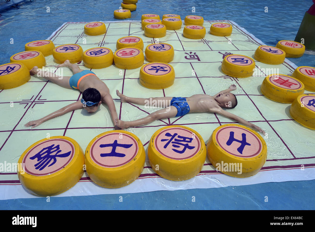 Chongqing, Chongqing, CHN. 7. Juli 2015. Chongqing, CHINA - 7. Juli 2015: (Nur zur redaktionellen Verwendung. CHINA aus) Menschen erleben Sie die Freude des Spielens chinesisches Schach im Wasser während einer Schachpartie im Wasserpark auf Yangren Straße. Wie Chongqing in heißen Tagen kommt, kurzem Wasserpark in Yangren Straße Unterhaltung des chinesischen Schach im Wasser für Touristen Urlaub verbringen. Das Jaint Schachbrett ist 20ãŽ¡und der Durchmesser jedes Schachfigur beträgt 50 cm. Credit: SIPA Asien/ZUMA Draht/Alamy Live News Stockfoto