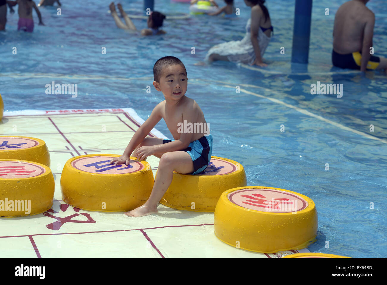 Chongqing, Chongqing, CHN. 7. Juli 2015. Chongqing, CHINA - 7. Juli 2015: (Nur zur redaktionellen Verwendung. CHINA aus) Menschen erleben Sie die Freude des Spielens chinesisches Schach im Wasser während einer Schachpartie im Wasserpark auf Yangren Straße. Wie Chongqing in heißen Tagen kommt, kurzem Wasserpark in Yangren Straße Unterhaltung des chinesischen Schach im Wasser für Touristen Urlaub verbringen. Das Jaint Schachbrett ist 20ãŽ¡und der Durchmesser jedes Schachfigur beträgt 50 cm. Credit: SIPA Asien/ZUMA Draht/Alamy Live News Stockfoto