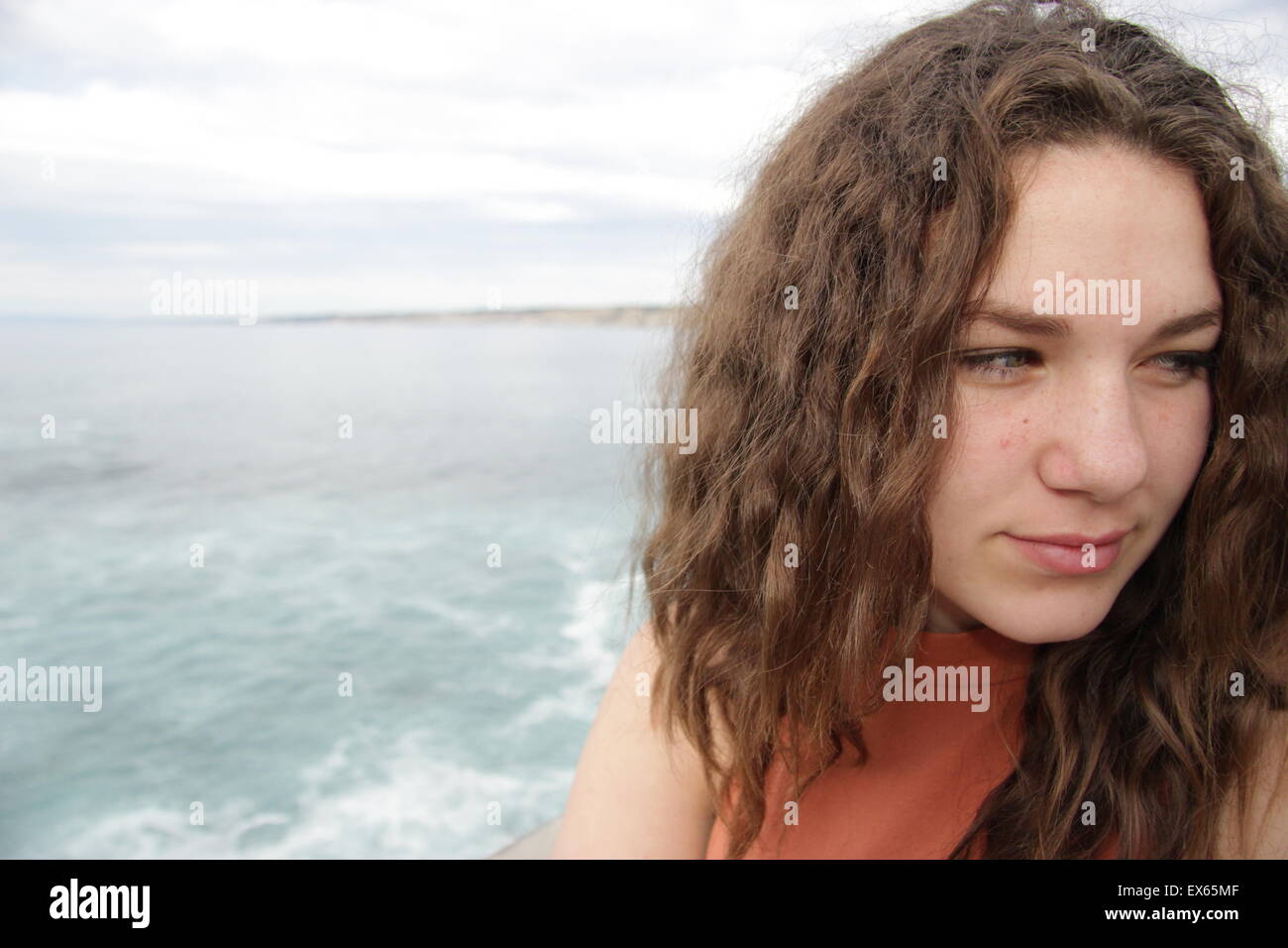 Eine schöne junge Frau mit einem Brennpunkt etwa basierend auf ihren Haaren und Augen. Hinter ihr, La Jolla Strand. Stockfoto