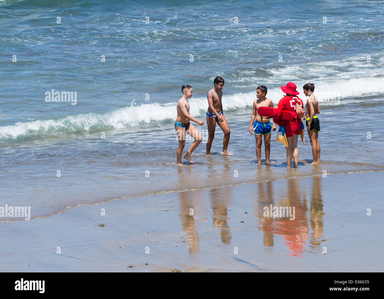 Rotes Kreuz (Cruz Roja) weiblichen Rettungsschwimmer erklärt die Gefahren des Gegenströmungen zu jungen am Strand sehr beliebt bei Surfern in Spanien Stockfoto