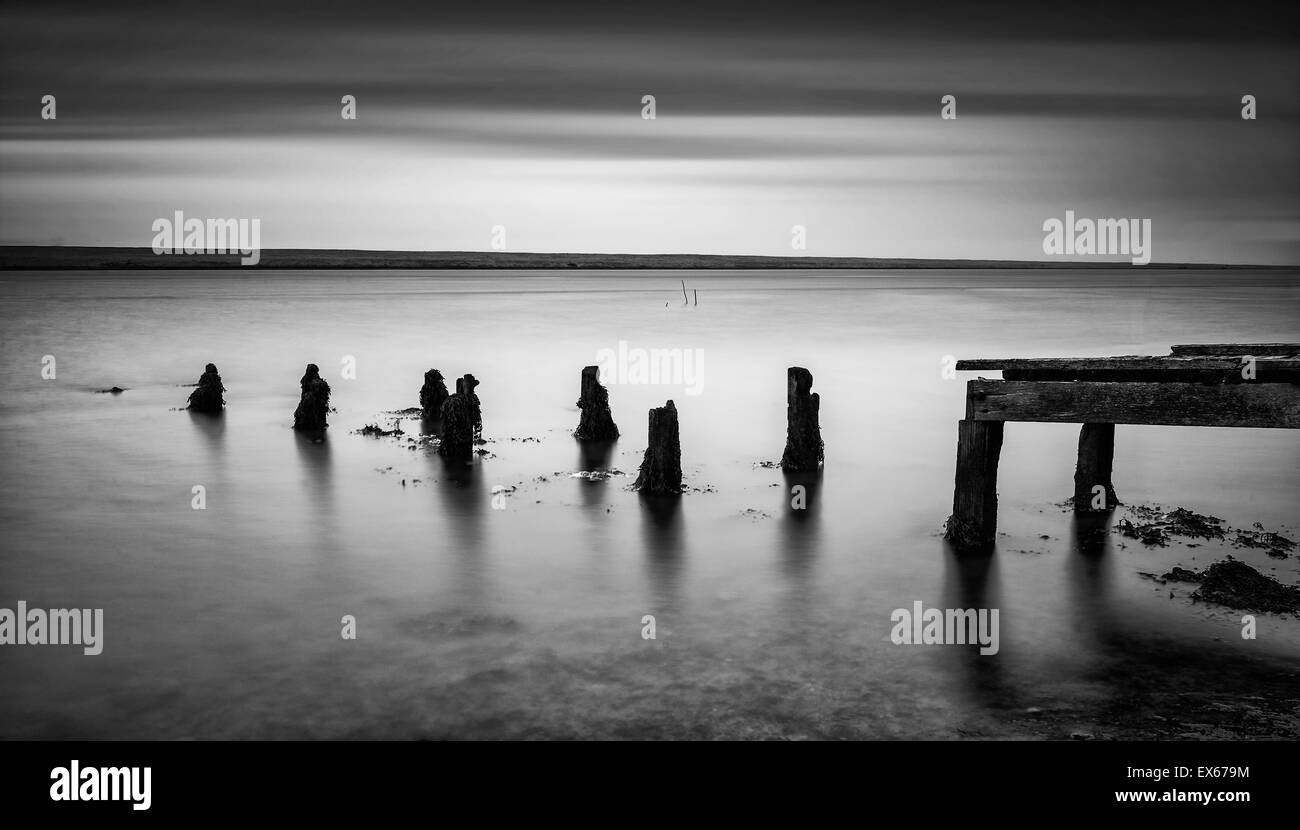 Lange Exposition Landschaft der alten Mole erstreckt sich in schwarzen und weißen See Stockfoto