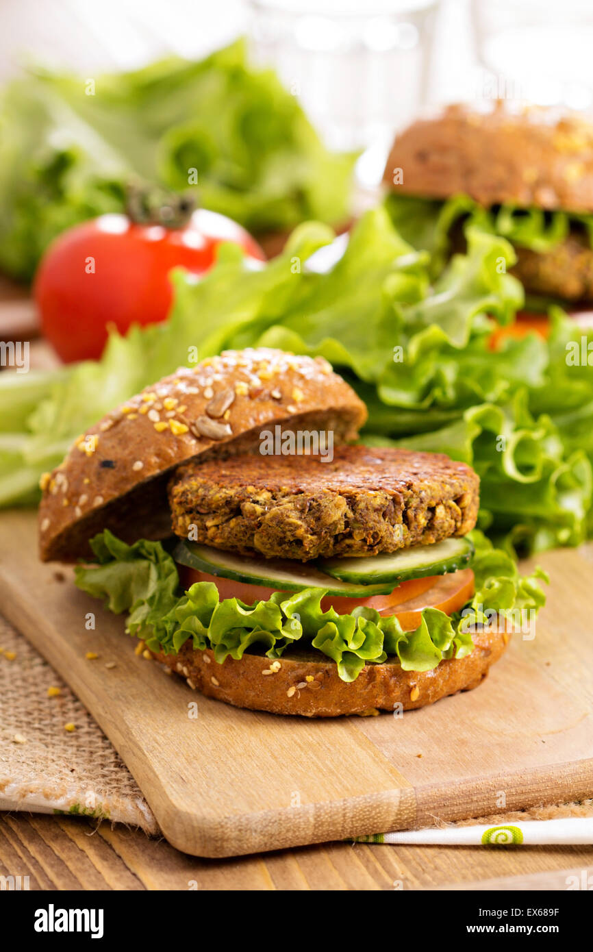 Vegane Burger mit Linsen und Pistashios gestapelt auf einem Schneidebrett Stockfoto