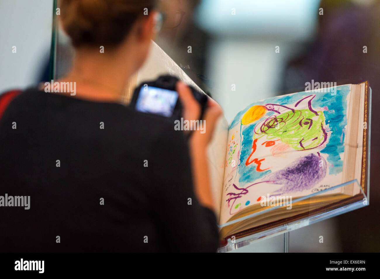 Ein Journalist nimmt ein Foto von einer Zeichnung von Marc Chagall von 1977, die in das Carnet d angezeigt wird "oder (lit.) Goldene Buch) der Porträt-Fotografen Eddy Novarro in der Ausstellung "Kaleidoskop der Neuzeit" im staatlichen Museum in Schwerin, Deutschland, 8. Juli 2015. In diesem Sommer zeigt das Museum Werke von verschiedenen Kunstströmungen wie der klassischen Moderne und der Pop Art. Alle Kunstwerke vorgestellt sind Teil der Sammlung des Fotografen Eddy Novarro (1925-2003), die gesammelten Kunstwerke und die jeweiligen Künstler fotografiert. Foto: JENS Büttner/dpa Stockfoto