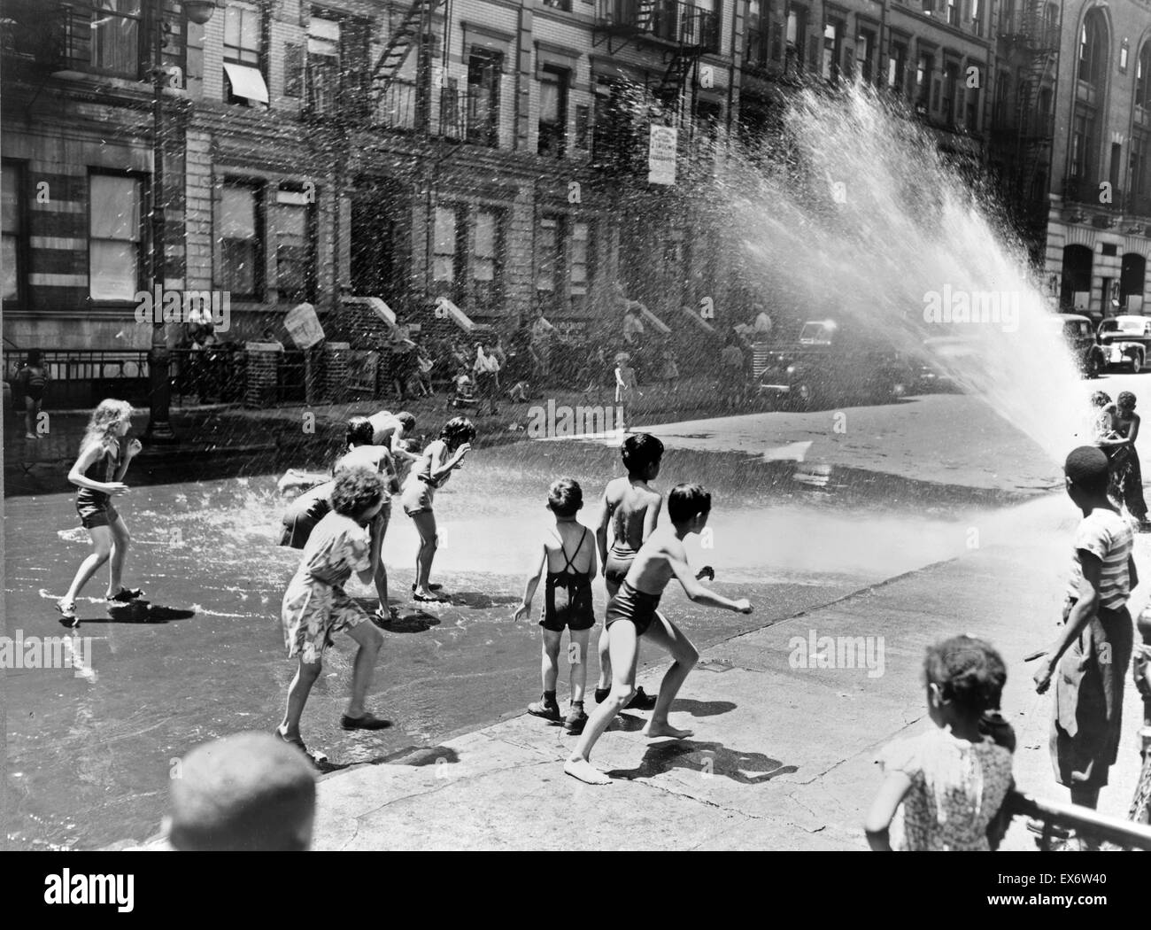 New York, New York. Kinder entfliehen Sie der Hitze der Ostseite mit Hydranten als ein Duschbad New York, New York. Kinder entfliehen Sie der Hitze der Ostseite mit Hydranten als ein Duschbad